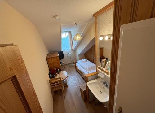 Un baño con lavabo y una cama en una habitación. en Beatenberg Resort & Spa in Beatenberg Interlaken, en Beatenberg