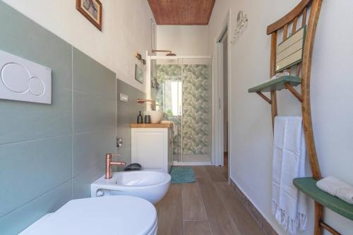 a bathroom with a white toilet and a sink at Casa con terrazza panoramica sul lago Maggiore in Maccagno con Pino e Veddasca