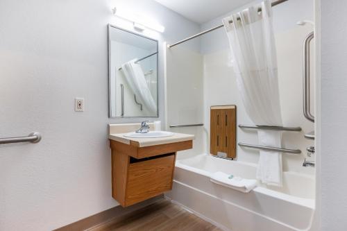 un baño con lavabo y bañera en Suburban Studios Huntsville University Area, en Huntsville