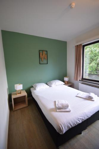 a bedroom with a large bed and a window at Budget Flats Brussels in Brussels