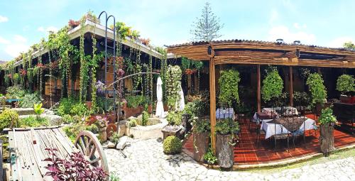 a garden with a pergola and a table and chairs at Hotel Eterna Primavera Antigua in Antigua Guatemala