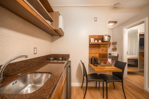 a kitchen with a sink and a table with chairs at Pousada dos Sonhos in Florianópolis