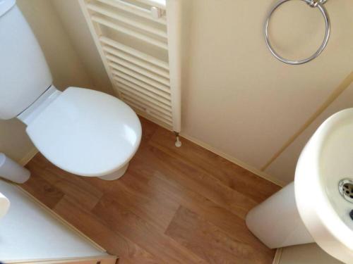 Un baño con un inodoro blanco y un lavabo. en Delightful Caravan With A Lake View At Southview Holiday Park Ref 33026Cl, en Winthorpe