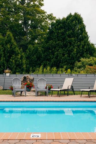 two chairs sitting next to a swimming pool at Mountain Inn at Killington in Killington