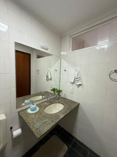 une salle de bain avec un lavabo et un miroir dans l'établissement Apart Pierbal Estilo, à Franca