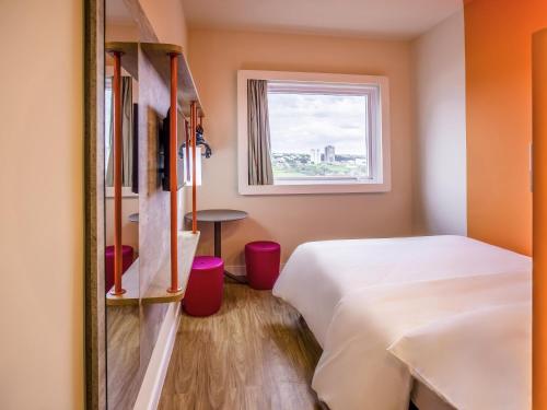 a hotel room with two beds and a window at Íbis Budget Uberlândia in Uberlândia