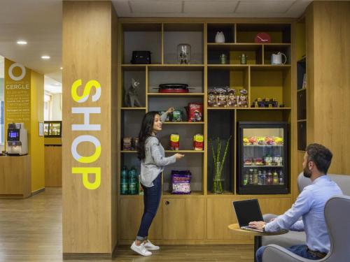 a woman standing in front of a shelf in a store at Aparthotel Adagio access Montpellier Centre in Montpellier