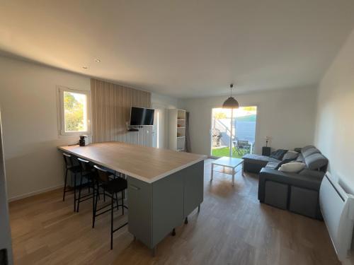 a kitchen and living room with a couch and a table at L'instant fleuri in Saint-Hippolyte