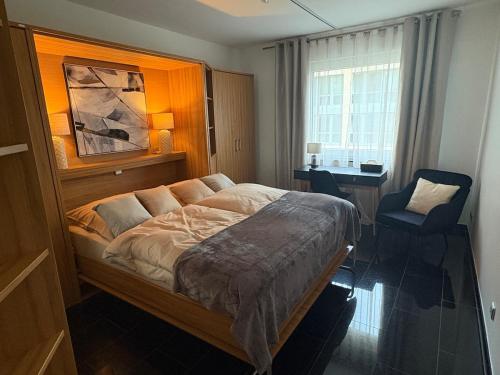 a bedroom with a bed and a chair and a window at Exclusives Apartment in Essen Rüttenscheid in Essen