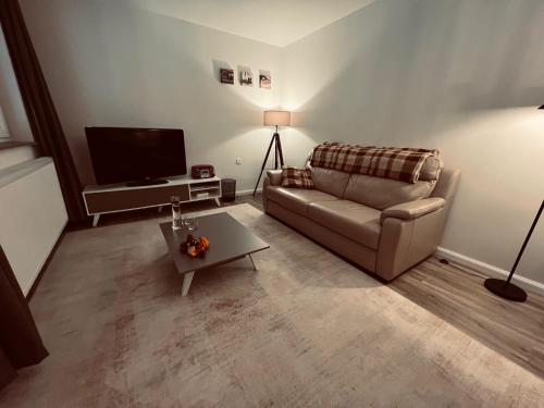 un salon avec un canapé et une table basse dans l'établissement Ruime suite met privé ingang en badkamer, à Genk