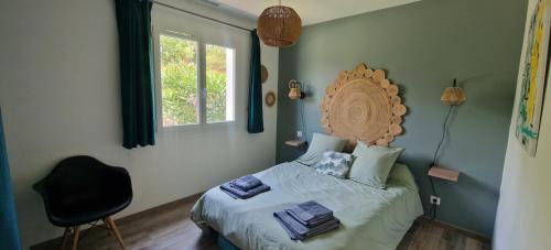 Un dormitorio con una cama y una silla y una ventana. en Villa Monplaisir, en Montolieu
