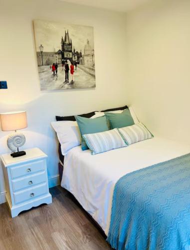 a bedroom with a bed and a night stand with a lamp at Cozy Private Access Room in Great Bookham