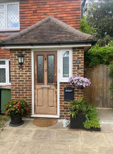 a brick house with a wooden door and flowers at Cozy Private Access Room in Moffat
