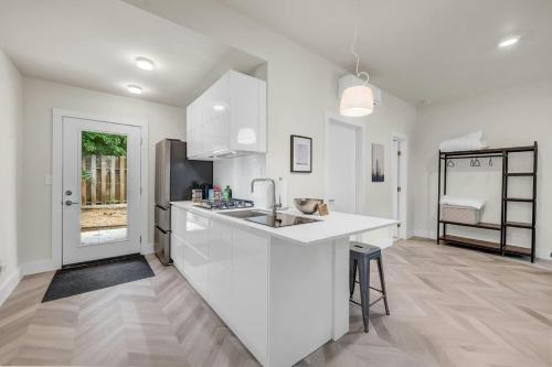 a white kitchen with a sink and a counter at Cozy studio in quiet area - Yard in Austin