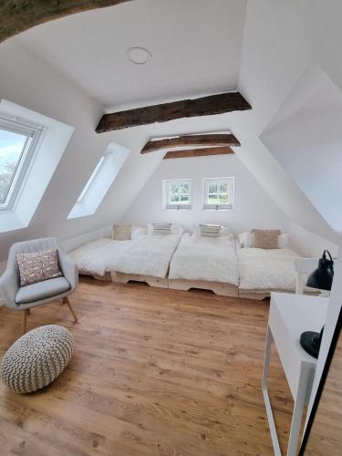 a attic bedroom with a large bed and a chair at Lichtdurchflutete Dachgeschosswohnung mit Charme in Goldenstedt