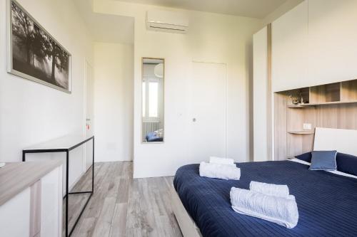 a bedroom with a blue bed with towels on it at Fiera aperto 24H - Bologna Accommodation in Bologna