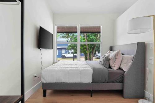 a bedroom with a bed and a window at Superb location steps to DT and UT in Austin