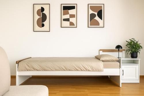 1 cama en una habitación con 4 cuadros en la pared en City Lodge Leipzig, en Leipzig