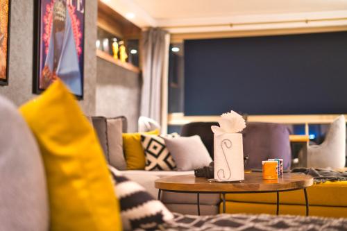 una sala de estar con un sofá y una mesa en Prestigia, superbe appartement, vue sur golf, piscine et Atlas, en Marrakech