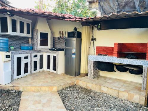  Il comprend une cuisine extérieure équipée d'une cuisinière et d'un réfrigérateur. dans l'établissement Villa de Grupo 16, Piscina Natural, Jacuzzi, Granja y Mascotas, Rosa & Deivi te esperan, à Villa Altagracia