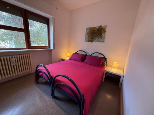 a bedroom with a pink bed with two tables and a window at Holiday B&B 1984 in Bari