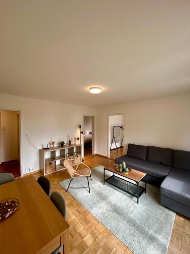 een woonkamer met een bank en een tafel bij Comfort escape on Schwandenwiesen in Zürich