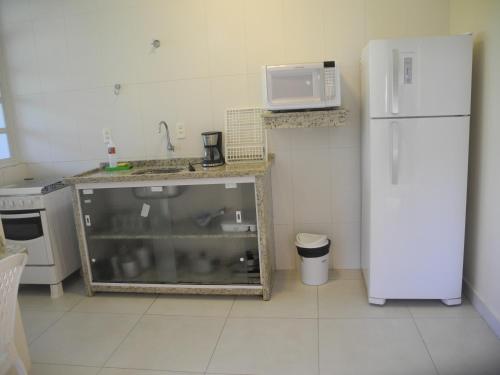 a kitchen with a fish tank and a white refrigerator at Pousada e Camping Lagoa da Conceição in Florianópolis