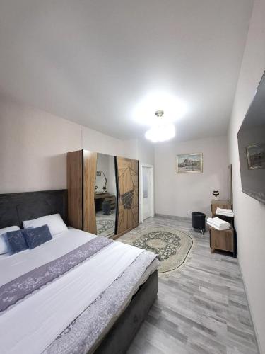 a bedroom with a large bed and a desk at Стильная студия в центре с кухней in Bukhara