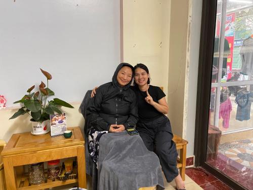 two people sitting on a bench posing for a picture at Moon Hotel in Mù Cang Chải