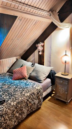 a bedroom with a bed and a table with a lamp at Domaine de la Borde in Damparis