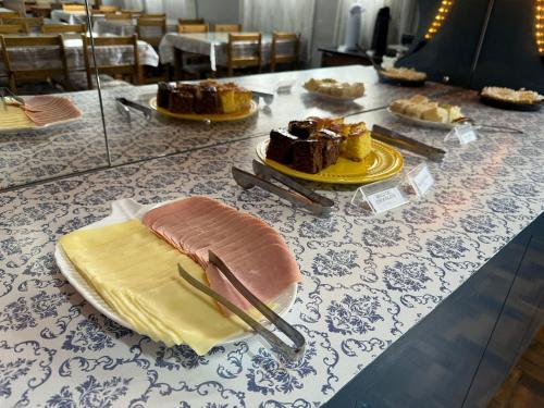a table topped with plates of food on a table at Pousada Vista do Lago: Lazer e família em Gramado! in Gramado