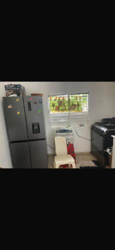 een keuken met een koelkast, een fornuis en een raam bij santo domingo airport villa in Reparto Esther Rosario