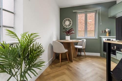 a kitchen and dining room with a table and a plant at Pippin - Stylish City Centre Studio - Worcester in Worcester
