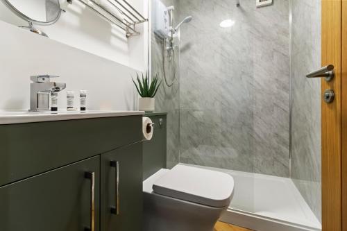 a bathroom with a shower and a toilet and a sink at Pippin - Stylish City Centre Studio - Worcester in Worcester