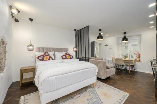 una camera da letto con un letto bianco e un soggiorno di Tallinn Old Hanza Apartments a Tallinn