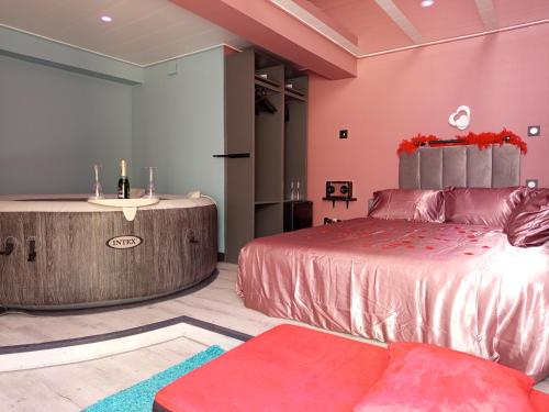 a room with a bed and a table and a couch at Chambre Romantique avec Spa Privé Intérieur in Rimons