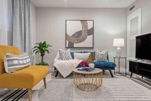 a living room with a blue couch and yellow chairs at Steps away from Downtown Restaurants and Bars - King Bed in Austin