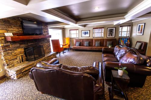 a living room with leather couches and a fireplace at The Mammoth Creek Inn in Mammoth Lakes