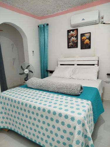 a bedroom with a bed with a blue and white blanket at Hotel El Almendro in Pedernales