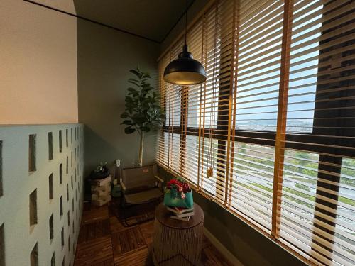 a room with a large window with a chair and a table at Chic Homestay with Mini Cafeteria at Gamuda Garden in Rawang