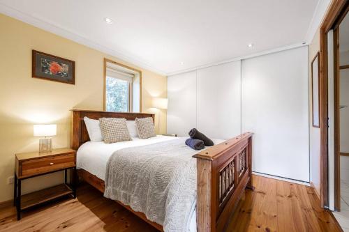 a bedroom with a large bed and a window at Tranquil Cottage with Valley and Hills Views in Wonga Park