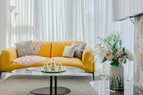 a living room with a yellow couch and a table at Chic Elegant City Center Condo in La Julia