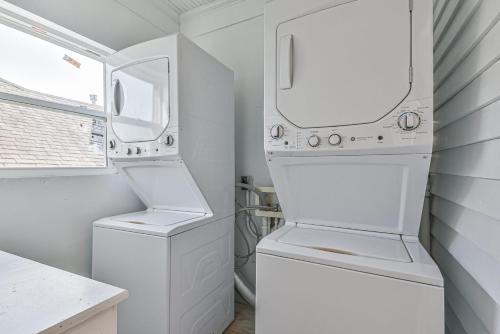 - une buanderie blanche avec lave-linge et sèche-linge dans l'établissement Cozy 2nd-Floor Suite near Beach, The Strand, Pier, à Galveston
