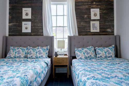 a bedroom with two beds and a window at Historic and charming duplex in desirable midtown, close to the beach and strand in Galveston