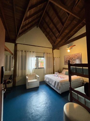 a bedroom with a bed and a chair in it at Portal do Sabiá Maresias in Maresias