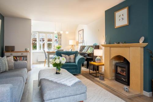 a living room with a couch and a fireplace at Old Orchard Cottage in Moreton in Marsh