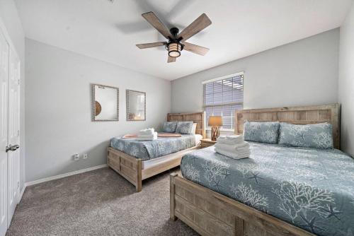 una camera da letto con due letti e un ventilatore a soffitto di Perfect Seabrook retreat just minutes from the bay with fire pit and Cowyboy soaking pool a Seabrook