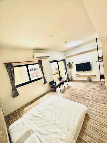 a large room with a bed and a flat screen tv at 竺韵旅宿 in Zhushan