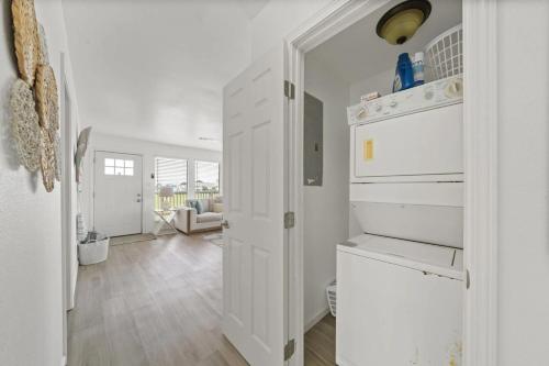 a kitchen with white cabinets and a living room at Bright and Cozy 4 Bedroom close to the Ocean in Galveston