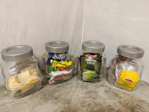 four glass jars filled with different types of food at Guesthouse 20 in Banting